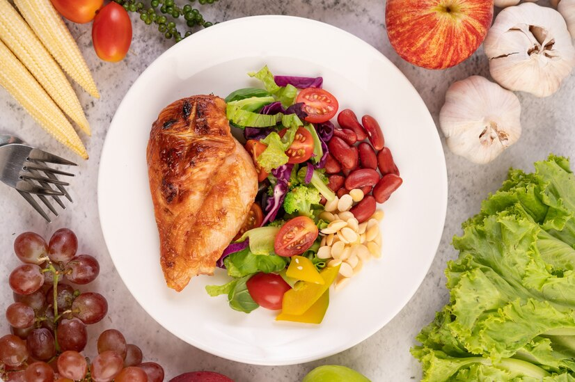 A display of healthy foods around and on a dinner plate.